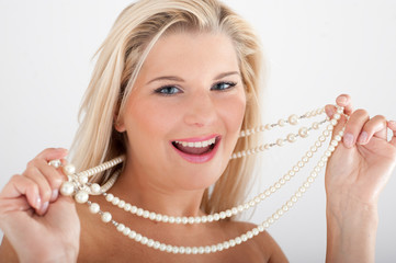 Young sexy woman with healthy white teeth and pearl necklace