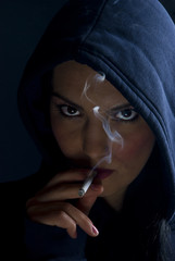 Woman hood smoking in dark