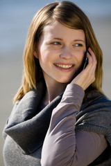 Frau telefoniert mit Mobiltelefon am Strand