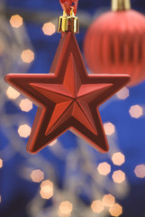 Hanging red Christmas star on blue background.