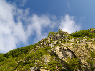 Stone declivity of mountain under cloudy sky