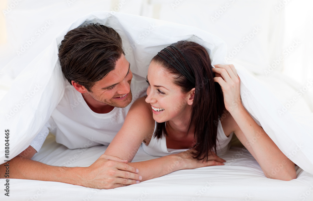 Wall mural Couple talking together and lying on bed