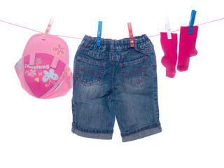 Baby clothes hang on clothesline.