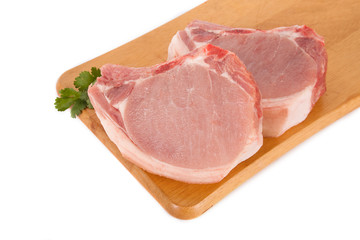 Fresh pork meat on wooden board with parsley