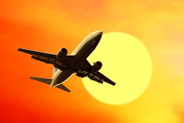 Airplane on sunset sky