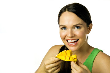 Young attractive happy woman eating mango isolated over white