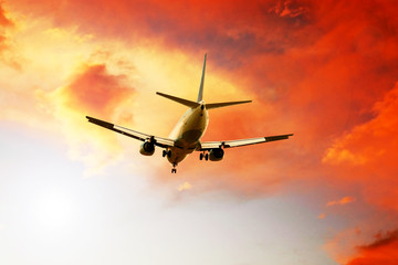 Airplane on sunset sky