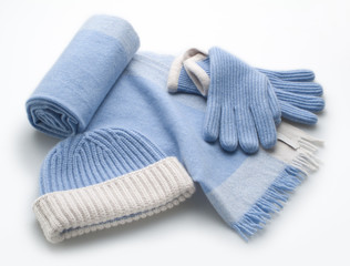 woolen light blue scarf, gloves and hat over white