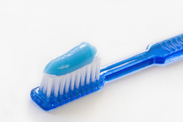 close-up of a blue toothbrush with toothpaste
