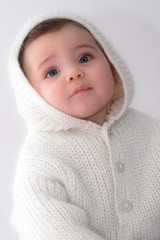 Bébé regardant vers le haut avec veste et capuche sur fond blanc