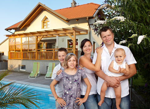 Young proud family with pool and house