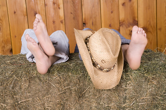 feet and hat on hay