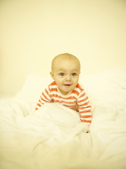 Baby Playing in White Bedding