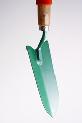 green garden shovel on a white background close up