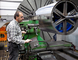 Älterer Arbeiter der Metallindustrie an CNC Fräsmaschine.