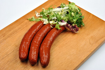 smoked sausage and organic gherkin on a timber board