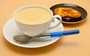 Closeup of coffee with milk in white cup and a palmier pastry