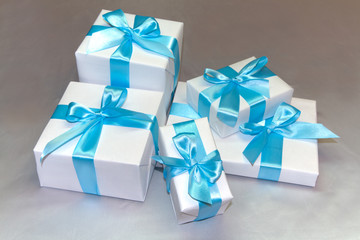 Cute white gift boxes with blue ribbon
