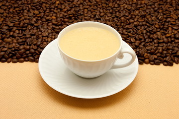 White cup of coffee and coffee beans