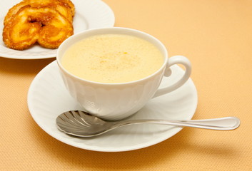 Closeup of coffee with milk in white cup and a palmier pastry