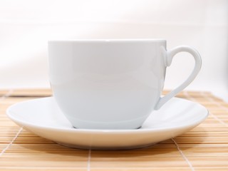 white cup  on bamboo