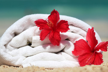 Biały ręcznik z białymi kwiatami na plaży