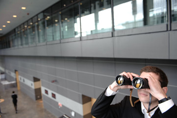 geschäftsmann mit fernglas in büro