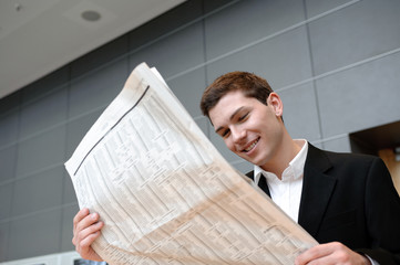 geschäftsmann liest in büro zeitung, gute nachrichten
