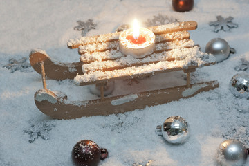 Schlitten mit Kerze im Schnee