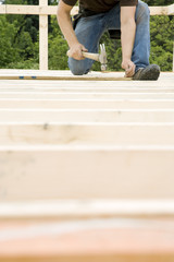 Carpenter Hammering Nail into Deck