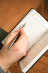Hand with pen in copybook