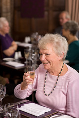 Happy senior lady in restaurant