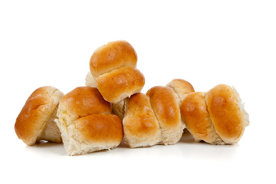 Golden baked dinner rolls on a white background