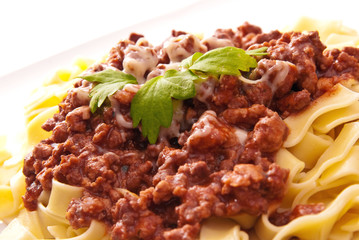 spaghetti bolognese with cheese on white plate
