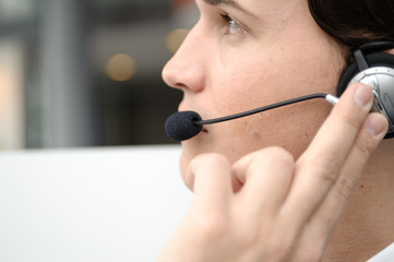 gesch&auml;ftsmann mit headset telefoniert mit kunden in b&uuml;ro