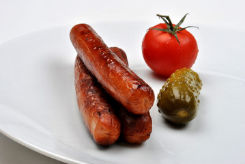 smoked sausage and organic gherkin on a timber board