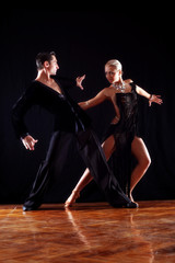 Fototapeta premium dancers in ballroom against black background