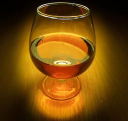 Glass of brandy with light on dark