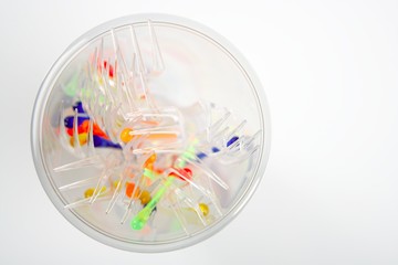 plastic glass with colorful sticks and forks
