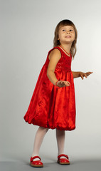Cute little girl in red dress dancing