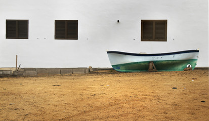 Fototapeta na wymiar Abandoned old boat against a wall (Canary Islands)
