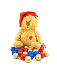 Toy bear in a Christmas cap and with Christmas-tree decorations