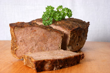 baked meat loaf with organic parsley on a timber board