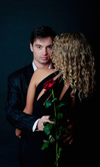 Man hug his woman and holding rose