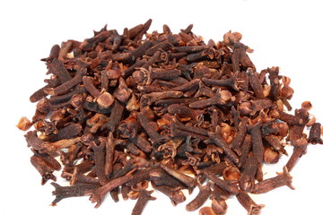 close up of a pile of dried cloves on a white background