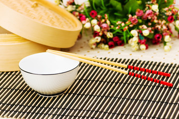 Chopsticks and bowl on the bamboo mat