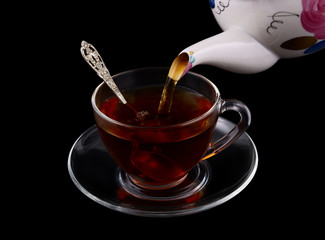 Fresh tea pouring isolated on black background