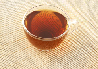 Glass cup of tea on wooden background