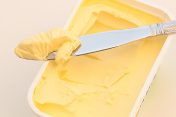 Knife with butter on a butter dish. - obrazy, fototapety, plakaty