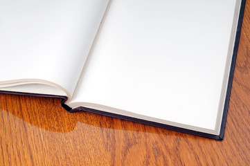 Blank open book with white page on wood background